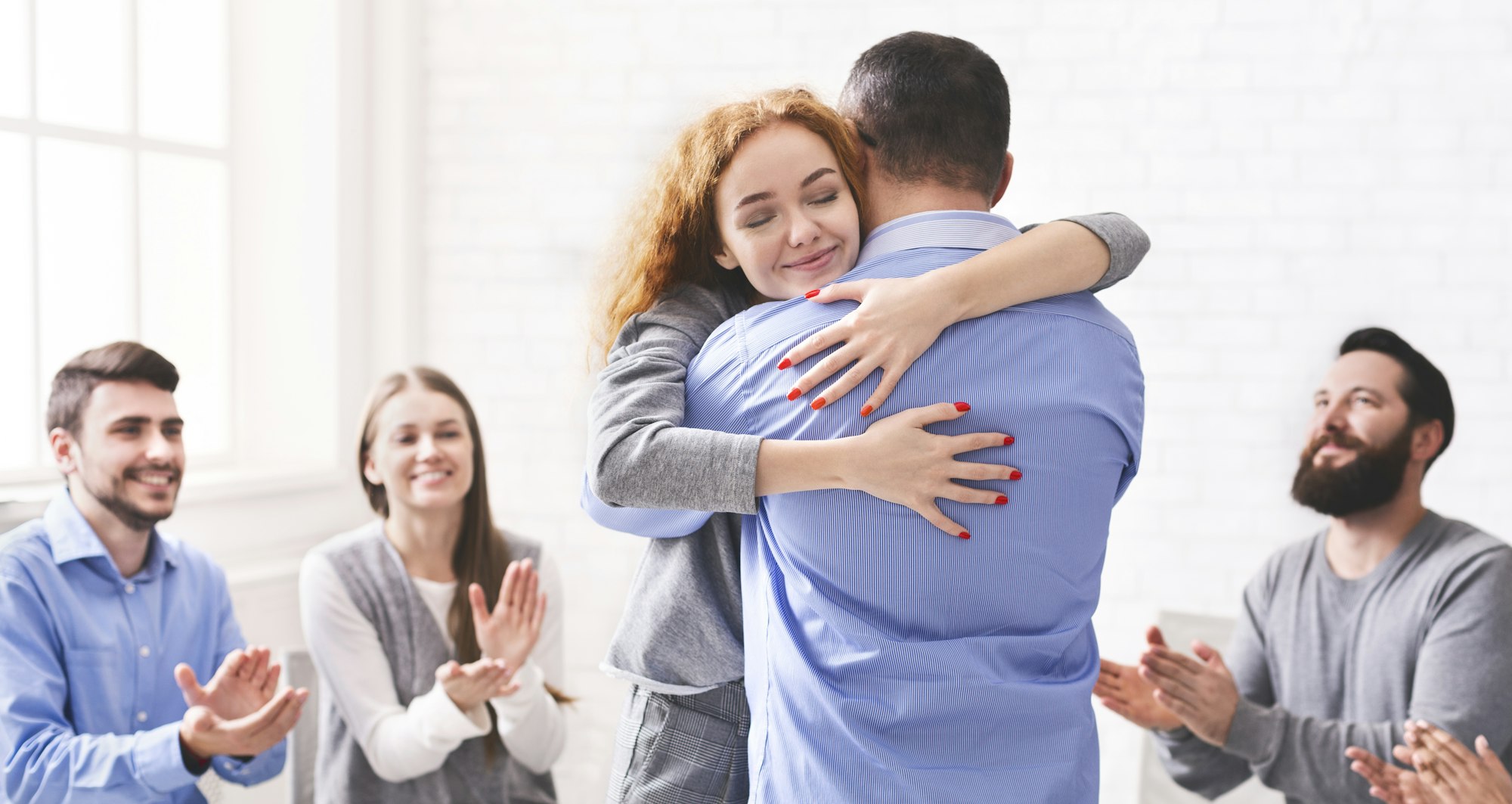 Happy Couple Hugging After Successful Group Therapy In Marriage Counsellor's Office